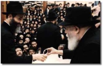 Herschel Lazaroff receiving wine from the Lubavitcher Rebbe in 1984